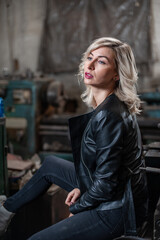 Portrait of a beautiful young blonde woman with blue eyes with old machinery 