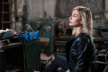 Portrait of a beautiful young blonde woman with blue eyes with old machinery 