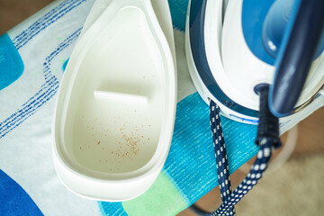 Close-up, top view, cleans the iron from the scale on the Ironing Board