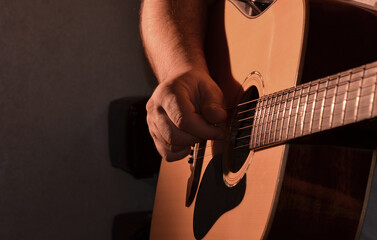 A man is learning to play the guitar.