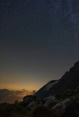 Sternenhimmel in den Alpen mit Wolken und Abendrot
