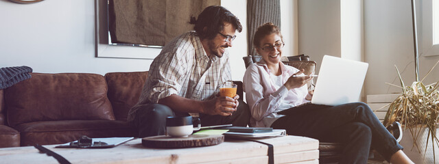 Group of two people with laptops in small loft office. Man and woman working together. Good new...