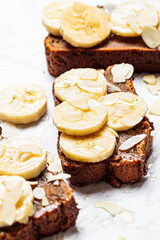 Pieces of banana bread with syrup and nuts on white background. Vegan dessert concept.
