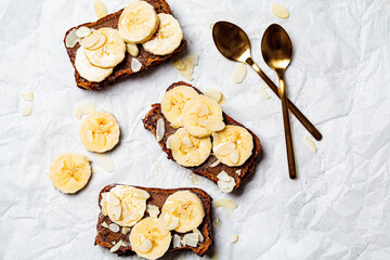 Flat lay pieces of banana bread with syrup and nuts on white background. Vegan dessert concept.