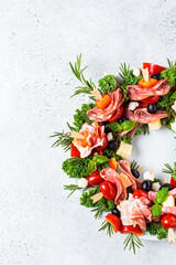 Fototapeta na wymiar Christmas wreath of festive appetizer. Canapes with cheese, vegetables and ham. Christmas food concept.