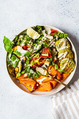 Falafel salad bowl. Vegan lunch plate - baked chickpea cutlets with baked sweet potatoes and vegetable salad in a white plate, top view.