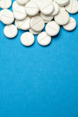group of white pills or tablets on blue background