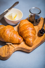 French croissant. Freshly baked croissants with jam on wooden background. Tasty croissants with copy space