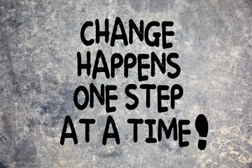 Change happens one step at at time quote written on stone background in nature. Development,...