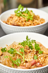 Cellophane noodles with chicken and bacon in a light plate