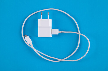 Isolated white charger on a blue background.
