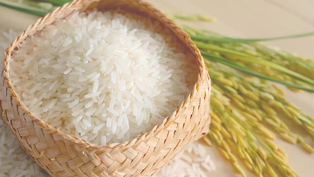 White rice (Thai Jasmine rice) in bamboo wood bowl on wood background.