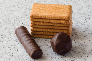 Rectangular shortbread cookies and chocolates on a light marble top.