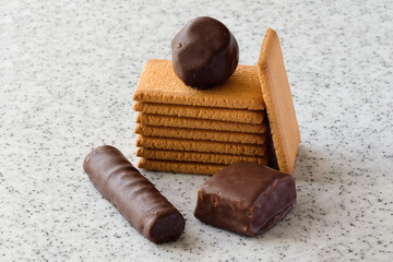 Rectangular shortbread cookies and chocolates on a light marble top.