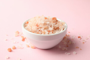 Bowl of pink himalayan salt on pink background
