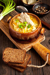 Sauerkraut soup in ceramic bowl on wooden table