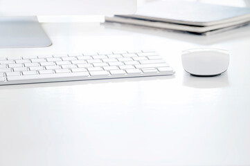 White computer keyboard and mouse on white top table, copy space.
