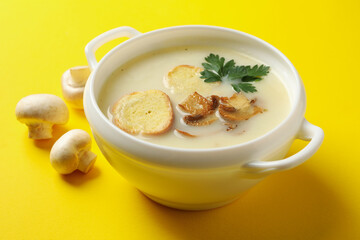 Bowl of tasty mushroom soup on yellow background
