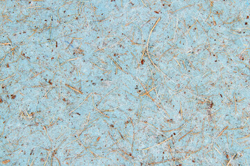 Blue paper cardboard with a rough coarse texture and wood chips. Abstract background.