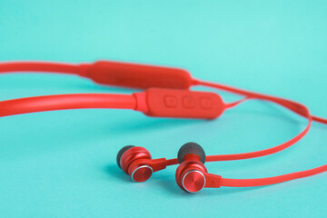 Naklejka premium Red earphones on bright blue background