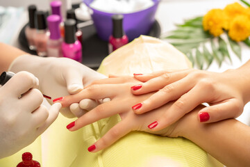 Obraz na płótnie Canvas Manicured polished fingernails in red at the beautician's salon.