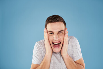 Emotional man in white t-shirt cropped view on blue background lifestyle