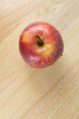 A fresh red apple on a wooden table