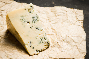 Tasty blue cheese on the rustic background. Selective focus. Shallow depth of field.