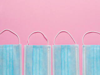 Medical protective masks on a pastel pink background. Individual, disposable surgical face mask...