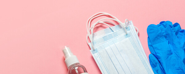 Medical protective mask, latex gloves, hand sanitizer on a pastel pink background. Individual, disposable hygiene equipment. Quarantine healthcare, hygiene and coronavirus protection concept.