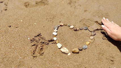 Stones in heart shape laid out by hand on sand of sesa beach