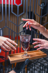 Many hands holding wine glass inside. Eating out in restaurant concept. Creative idea.