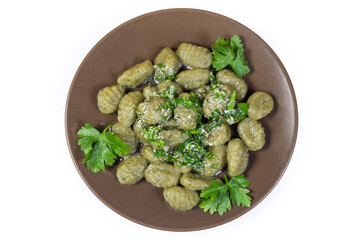 Potato spinach gnocchi with sauce on white background, top view