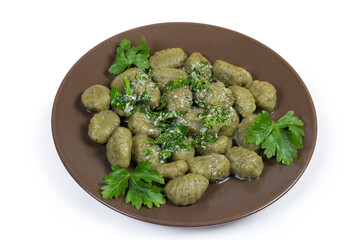 Portion of potato spinach gnocchi with sauce on white background