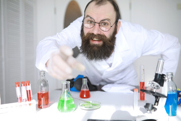 Chemist crazy. A mad scientist conducts experiments in a scientific laboratory. Performs research using a microscope.