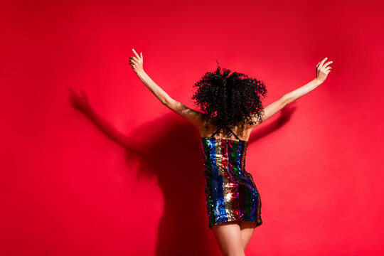 Rear back behind view of her stunning slender wavy-haired girl having fun dancing disco rest isolated over vibrant red color background