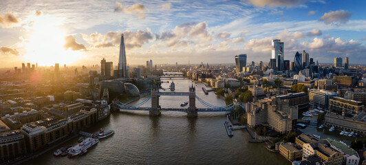 Die moderne Skyline von London, Großbritannien, bei Sonnenuntergang mit Tower Brücke, der City und den Wolkenkratzern entlang der Themse - obrazy, fototapety, plakaty