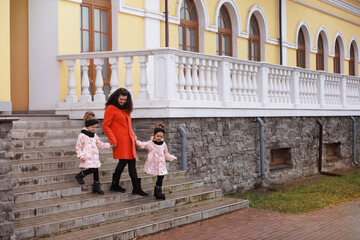 Young family on a walk in the autumn park on a sunny day. Happiness to be together.