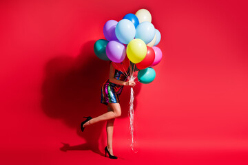 Full length profile photo of girl hold many balloons hide face wear glossy mini dress high heels...