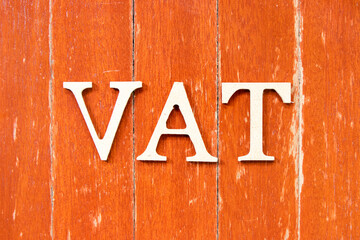 Alphabet letter in word vat (abbreviation of value added tax) on old red color wood plate background