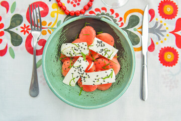Greek watermelon salad with feta cheese and basil. Delicious summer meal in a restaurant outside, eating out concept.