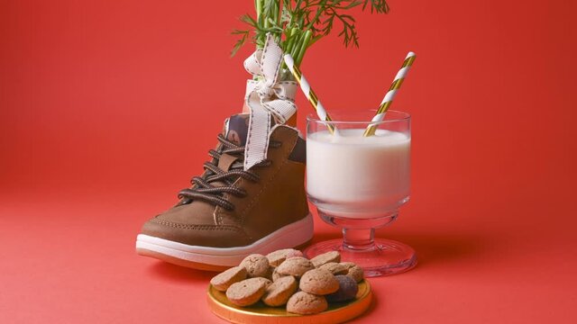 hildrens shoe with carrots for Santa's horse, milk, pepernoten and sweets on a bright background. Dutch holiday Sinterklaas. Stop mo.