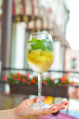Glass of white wine with melon pieces. Delicious cold fruit drink served in glass.