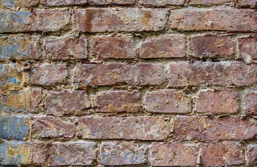 Old, weathered brickwork with crumbling plaster. Background. Vintage.