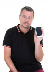 handsome serious man holding blank phone with empty black screen isolated on white background