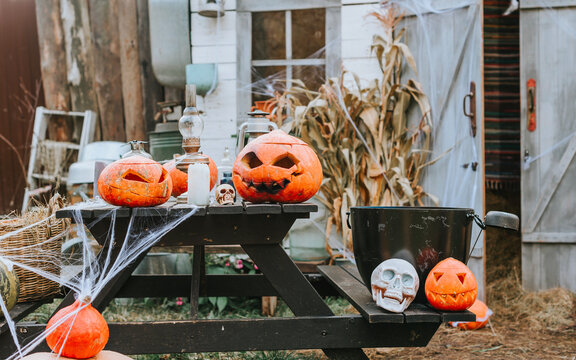 A Barn Decorated For Halloween With Carved Pumpkins And Cobwebs