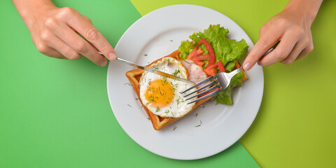 Sour waffle with fried egg and vegetables on a plate. Delicious traditional breakfast idea. Belgian waffle recipe.