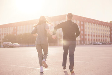 young couple run in the street on summer day holding hands, holidays weekend happy life