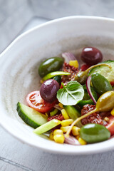 Simple Salad with Green and Kalamata Olives, Cucumber, Cherry and marinated Tomatoes, Capers and Jalapeno Pepper. Close up.	