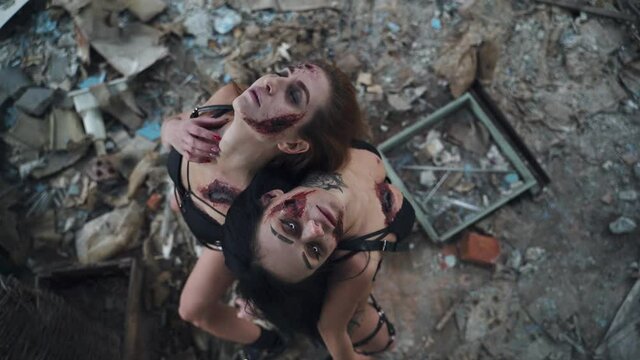 Two young zombie women in black underwear with bloody wounds on their bodies. images for halloween